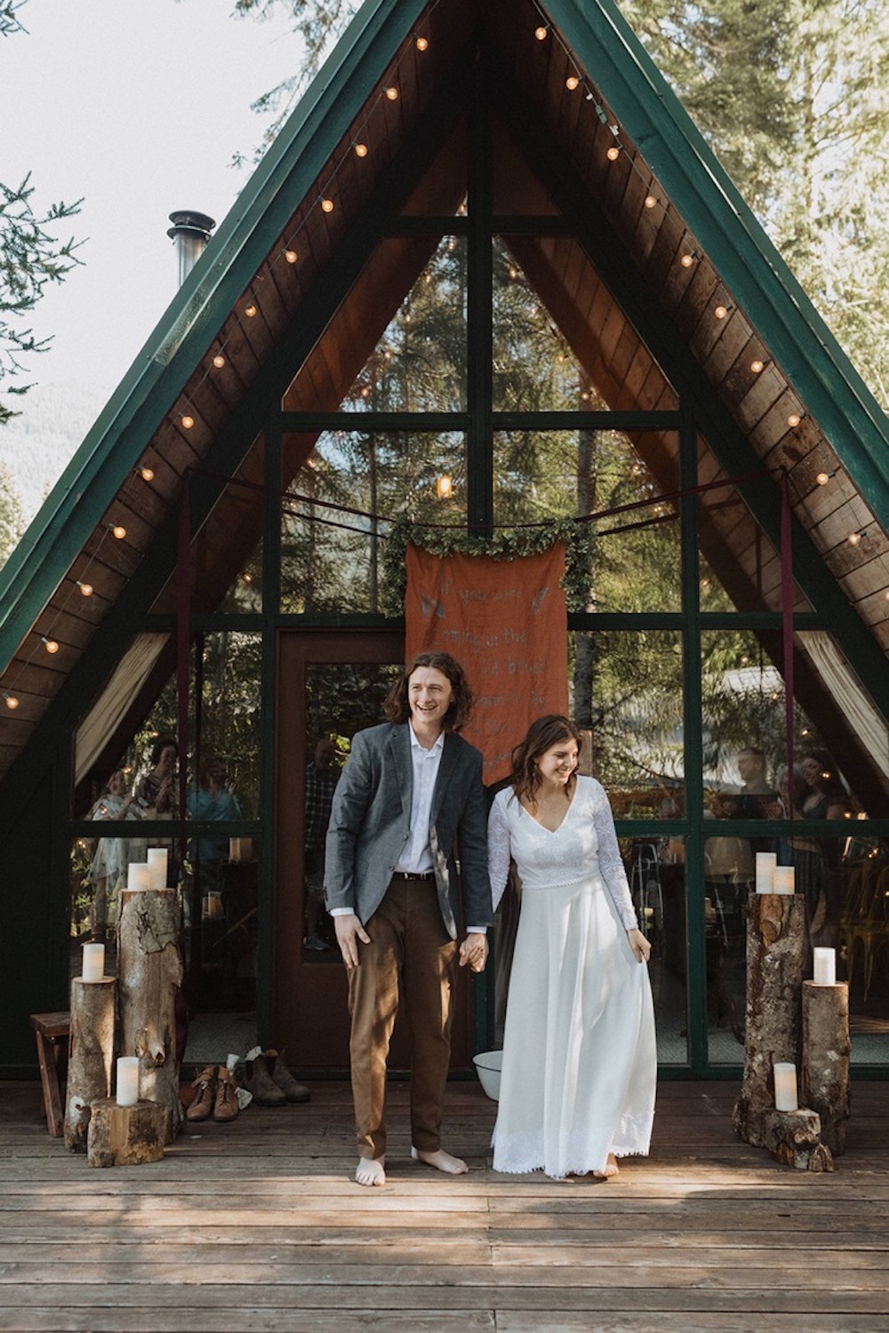Couple smile as they pose in front of the Spacious, Bright Cabin near Mt Rainier