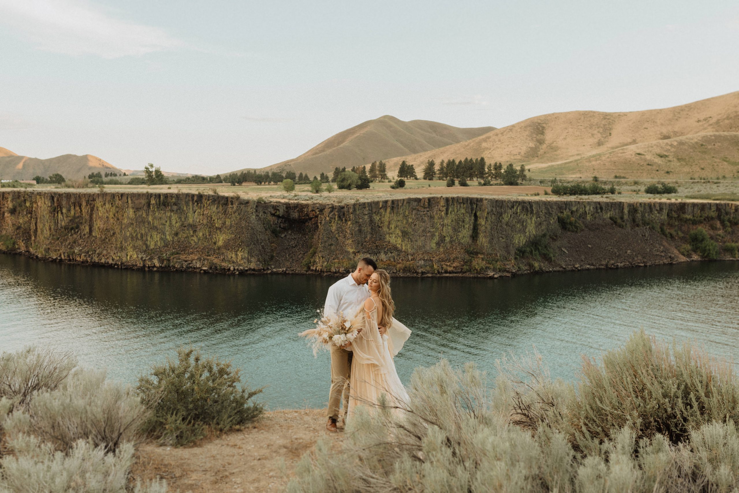 Bride and groom pose near a lake during their elopement session in Idaho, photographed by Alexa Ann