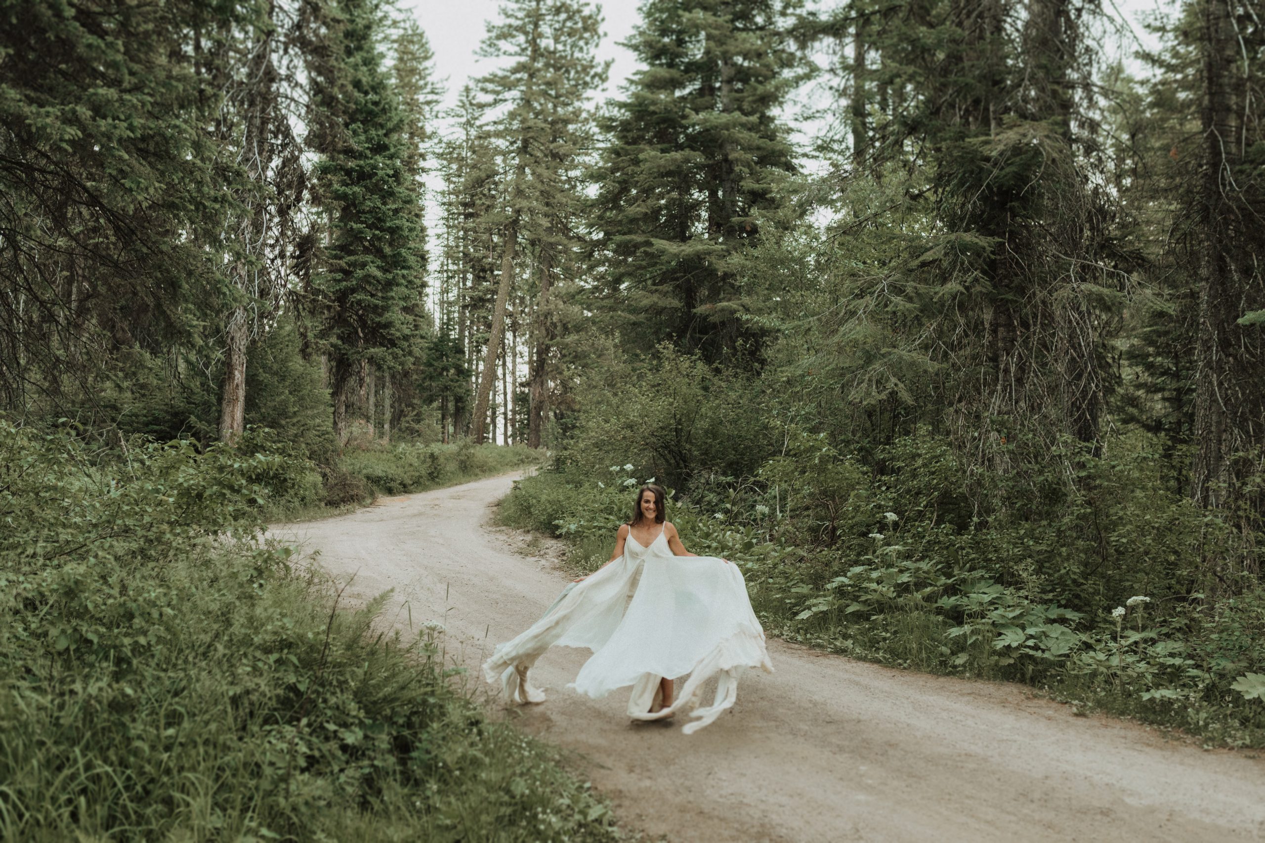 Bride posing in her dress in the middle of Baker Lake Trail during their elopement shoot