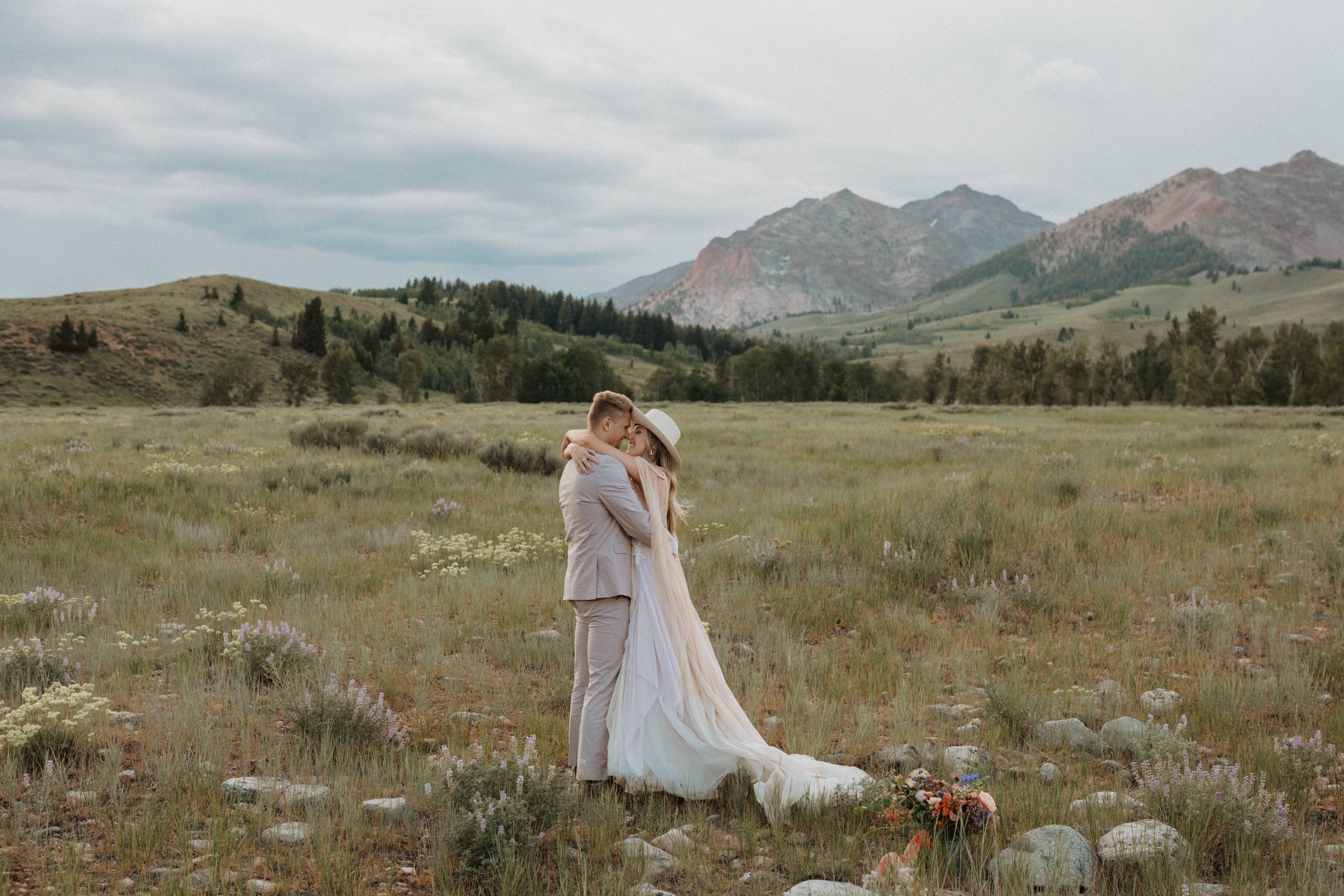 Couple kissing with mountain view behind them, captured by Alexa Ann Photography