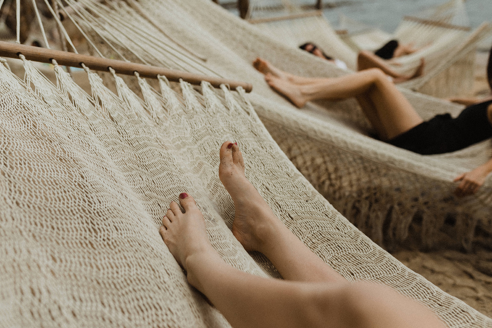 How to Elope in Mexico: Close-up shot of people lounging and laying on hammocks during their adventure elopement.