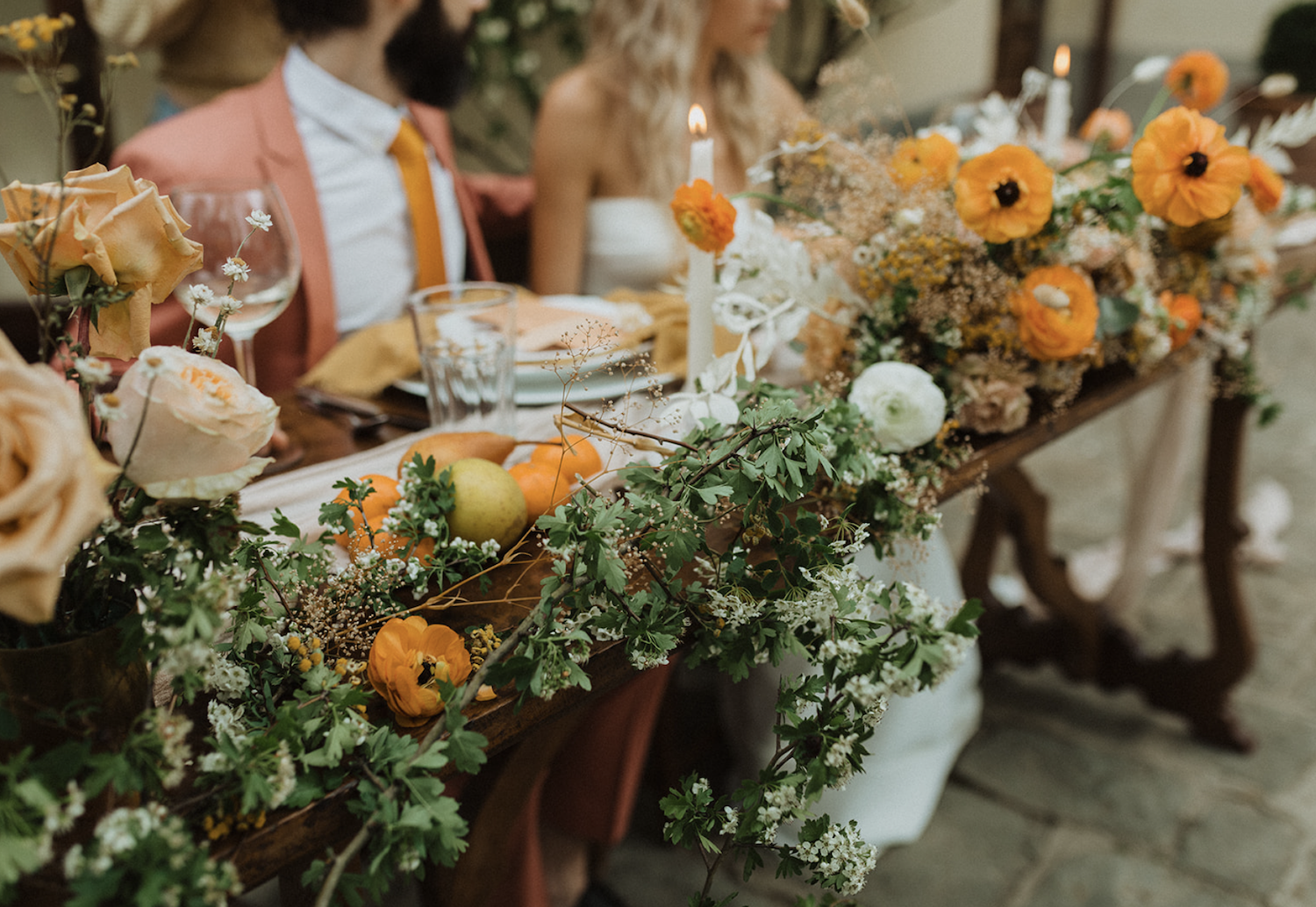 Close-up shot of bride and groom seated at their table filled with flowers at their reception, shot by PNW elopement photographer Alexa Ann