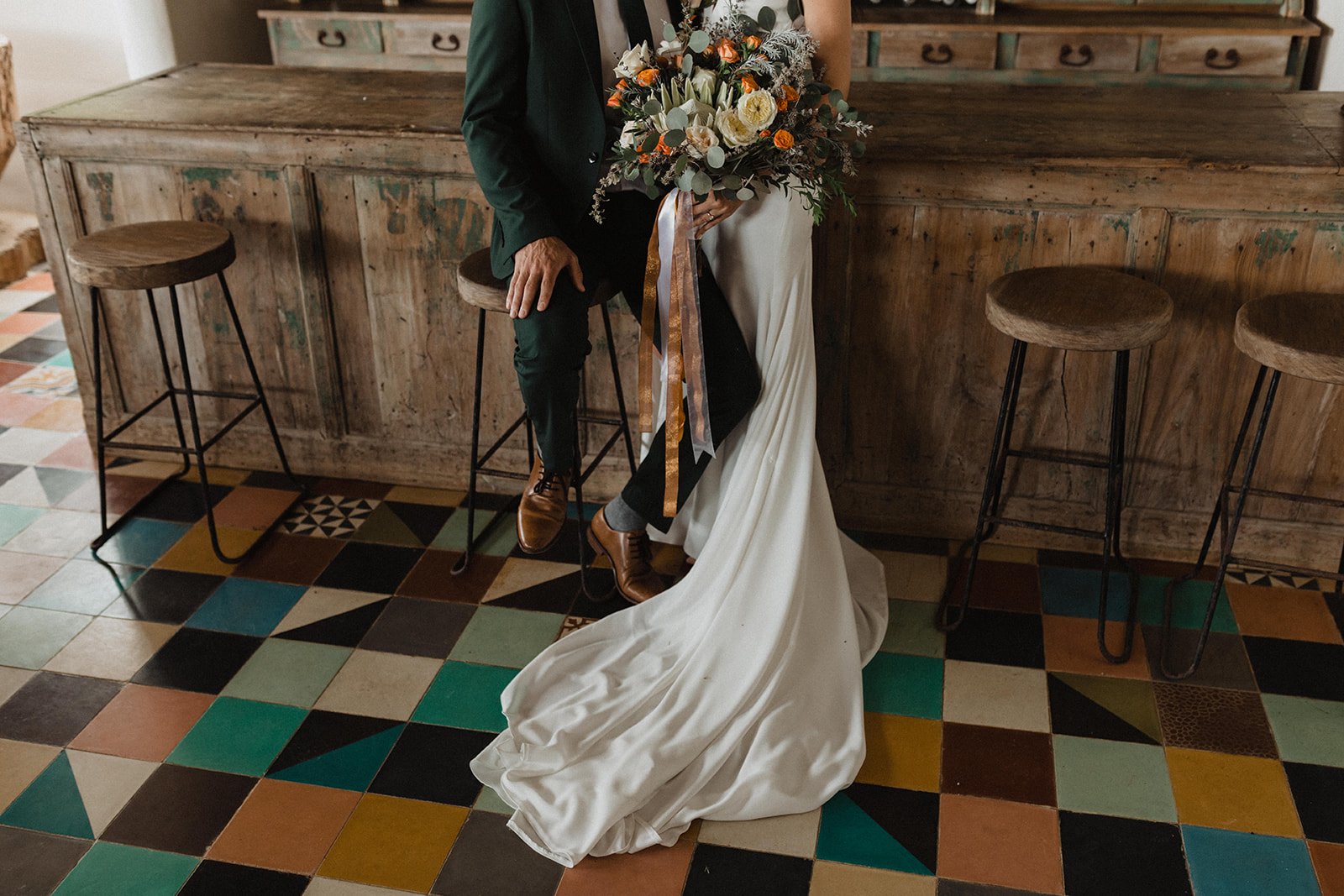 Close-up shot of bride and groom sitting on bar stools during their elopement shoot with Alexa Ann Photography