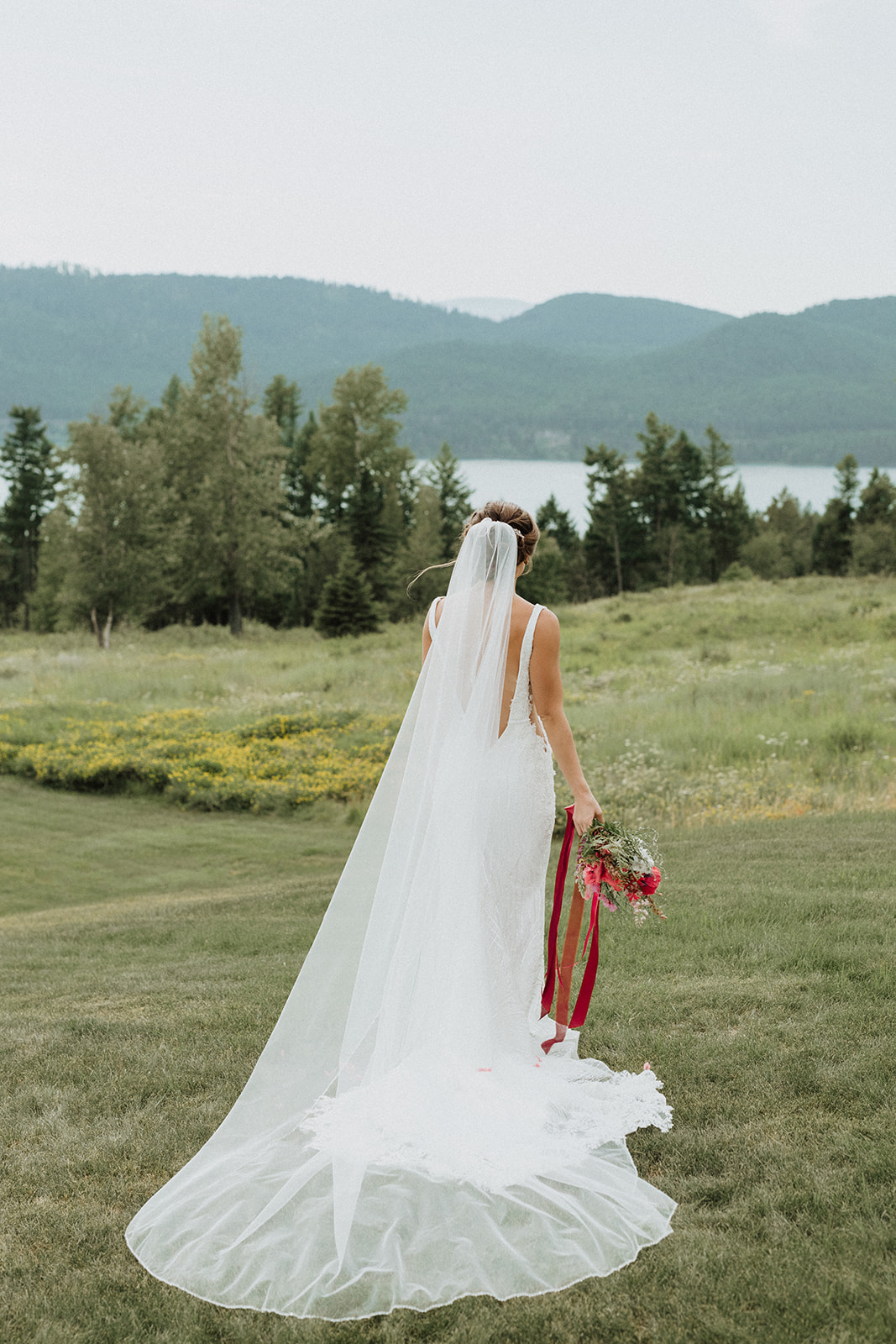 Bride standing with her back to the camera with her cathedral length veil during Montana elopement