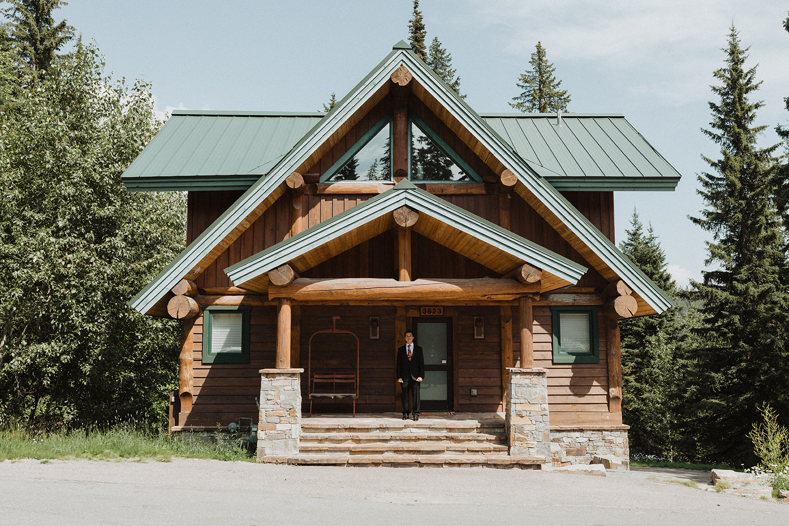 Montana Elopement Planning Guide and Locations: View of lodging from outside with groom standing at entrance