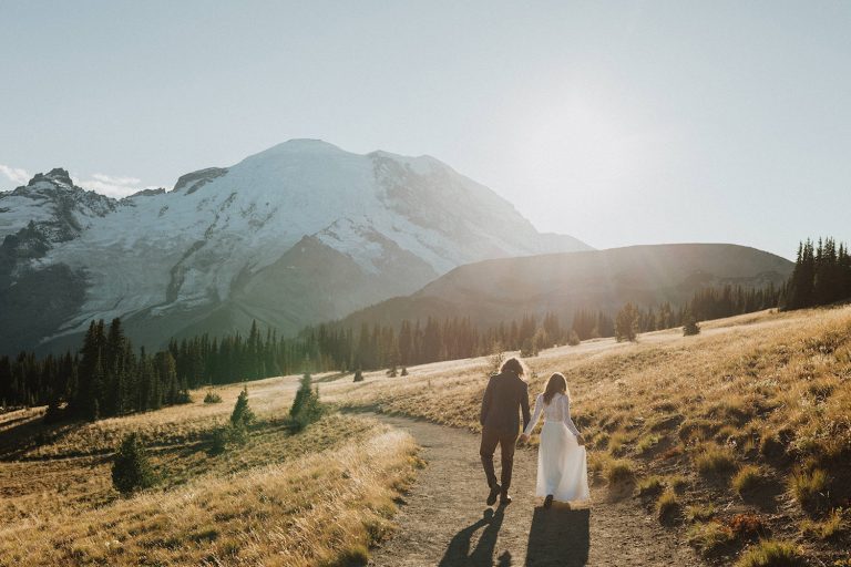 A newlywed couple holds hands while walking down a trail at a Washington National Park during golden of their Washington elopement