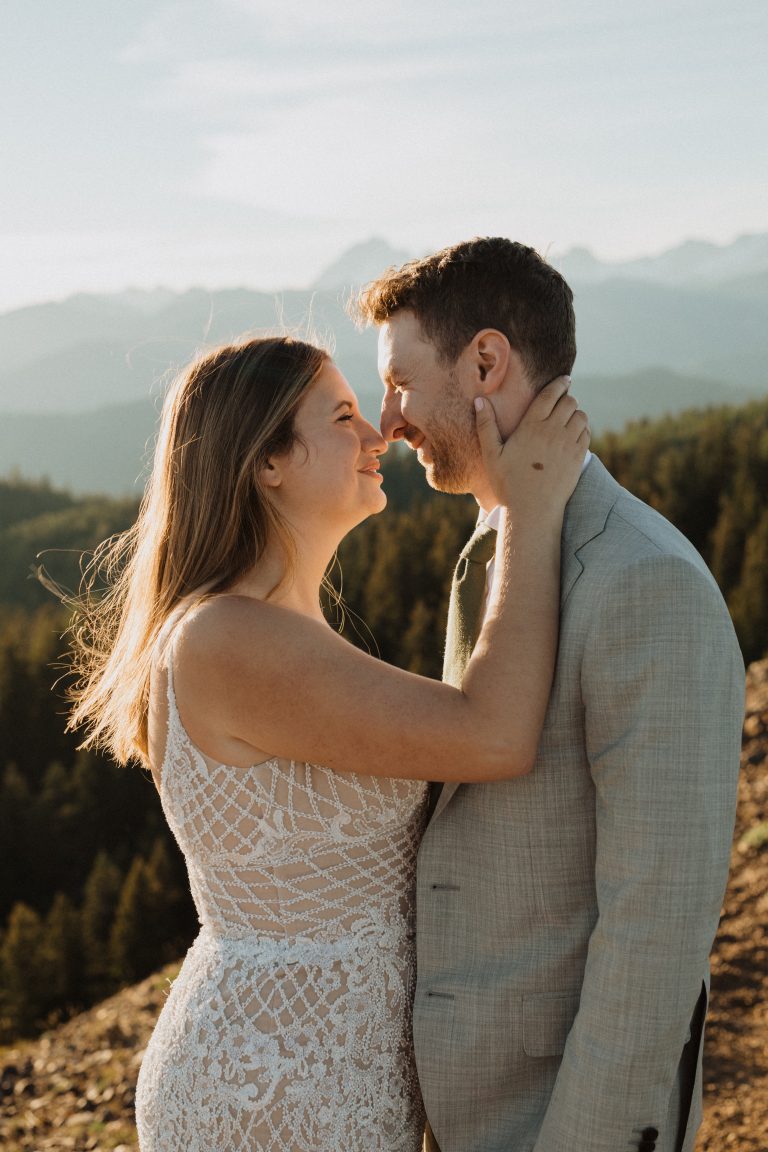 Bride and groom stand close to each other as the bride touches the groom's face, captured by Alexa Ann Photography