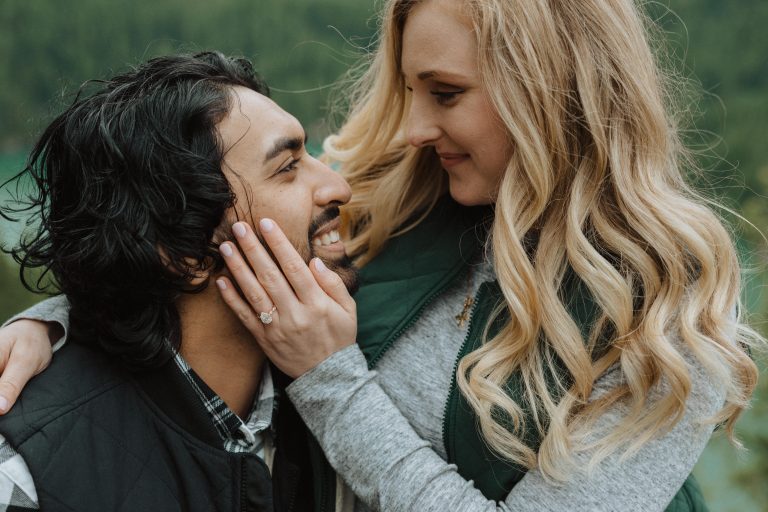 Close-up shot of the girl touching the guy’s face, showing the gorgeous engagement ring on her finger, during the north cascades proposal shot by Alexa Ann Photography